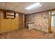 Finished basement area featuring exposed brick, a built-in bar area, and wood paneling at 237 Fea Ln, Iron Station, NC 28080