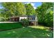 Unique home exterior featuring a sunroom on stilts, a covered carport, and outdoor patio at 237 Fea Ln, Iron Station, NC 28080