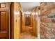 Hallway with wood paneling, brick accent wall, and doorways leading to other rooms at 237 Fea Ln, Iron Station, NC 28080