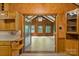 Rustic kitchen featuring wood cabinets and doorway view to sunroom with vaulted ceiling at 237 Fea Ln, Iron Station, NC 28080