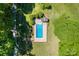 Aerial view of a sparkling blue in-ground pool surrounded by a manicured lawn, shrubs and shade trees at 237 Fea Ln, Iron Station, NC 28080