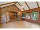 Sun room featuring brick accent wall, wood paneling, vaulted ceiling, and walls of windows at 237 Fea Ln, Iron Station, NC 28080