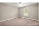 Bedroom features bright window, neutral walls, ceiling fan and carpet at 2412 Laura Dr, Charlotte, NC 28212