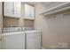 Functional laundry room equipped with a washer, dryer, shelving, and ample storage space at 2412 Laura Dr, Charlotte, NC 28212