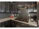 Close-up of the kitchen's gas cooktop, mosaic backsplash, and dark wood cabinets with white countertops at 3119 Castlemaine Dr, Charlotte, NC 28269