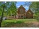 Spacious brick home backyard features a deck with patio and green lawn at 3124 Lakewood Edge Dr, Charlotte, NC 28269