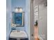 A bright half-bathroom with blue walls, vanity, and a mirror at 3124 Lakewood Edge Dr, Charlotte, NC 28269