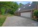 Brick home features a two-car garage and driveway lined with lush greenery at 3124 Lakewood Edge Dr, Charlotte, NC 28269