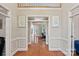 Hallway with hardwood floors and detailed trim, offers a view of the living room and a cozy office at 3124 Lakewood Edge Dr, Charlotte, NC 28269