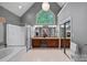 A spacious main bathroom with a large window, double vanity, soaking tub, and a walk-in shower at 3124 Lakewood Edge Dr, Charlotte, NC 28269