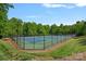 Well-maintained tennis courts surrounded by a secure fence and lush greenery; perfect for recreational enjoyment at 3124 Lakewood Edge Dr, Charlotte, NC 28269