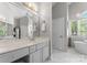 Bright bathroom with double vanity, marble floors, pendant lighting, and a soaking tub at 3507 Governors Island Dr, Denver, NC 28037