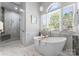 Bright bathroom with marble floors, soaking tub, and a glass walk-in shower at 3507 Governors Island Dr, Denver, NC 28037