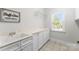 Bright laundry room with white cabinets, sink, and marble countertop at 3507 Governors Island Dr, Denver, NC 28037
