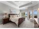 Beautiful bedroom featuring tray ceilings, neutral walls, carpet, and lake views at 3507 Governors Island Dr, Denver, NC 28037