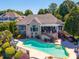 A beautiful pool with an outdoor seating area is the focal point of this home's backyard at 3507 Governors Island Dr, Denver, NC 28037