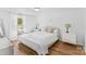 Bright bedroom featuring hardwood floors, a cozy bed with plush pillows, and two white bedside tables with stylish lamps at 355 Jared Steel Ln, Salisbury, NC 28146
