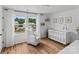 Charming Bedroom with hardwood floors, large windows, a cozy armchair, and a white crib with a cute mobile at 355 Jared Steel Ln, Salisbury, NC 28146