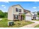 Beige two-story home with a white garage door and a small tree in the front yard under a blue sky at 355 Jared Steel Ln, Salisbury, NC 28146