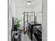 Bright laundry room with modern washer and dryer, a decorative folding screen, and stylish black metal shelving for storage at 355 Jared Steel Ln, Salisbury, NC 28146