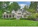 Lush backyard showcases a pristine lawn, beautiful landscaping, and a view of the home's architecture and outdoor living spaces at 3950 Abingdon Rd, Charlotte, NC 28211