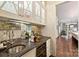Stylish bar area with glass cabinets, a mirrored backsplash, and modern fixtures at 3950 Abingdon Rd, Charlotte, NC 28211