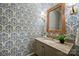 Charming powder room boasts patterned wallpaper, a stylish vanity, and decorative mirror at 3950 Abingdon Rd, Charlotte, NC 28211