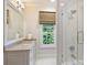 Well-lit bathroom boasts a spacious walk-in shower, vanity, and a large window offering natural light and views at 3950 Abingdon Rd, Charlotte, NC 28211