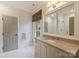 Bright bathroom features a large vanity, hexagon tile floors, and window with blinds at 3950 Abingdon Rd, Charlotte, NC 28211