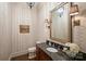 Elegant bathroom features a dark wood vanity, marble countertop, and decorative sconces at 3950 Abingdon Rd, Charlotte, NC 28211