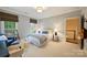 Comfortable bedroom with neutral tones, two windows, and convenient access to the hallway at 3950 Abingdon Rd, Charlotte, NC 28211