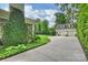 Long driveway leading to a three car garage with a basketball hoop and lush landscaping at 3950 Abingdon Rd, Charlotte, NC 28211