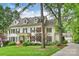 Elegant home with a side view revealing the garage and driveway, framed by lush landscaping at 3950 Abingdon Rd, Charlotte, NC 28211
