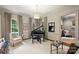 Cozy living room featuring a grand piano, large windows, and neutral decor at 3950 Abingdon Rd, Charlotte, NC 28211