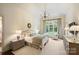 Serene main bedroom featuring a king-size bed, soft lighting, and a large window with lush views at 3950 Abingdon Rd, Charlotte, NC 28211