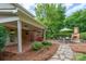 Backyard patio area featuring outdoor seating, landscaping, and a brick fireplace at 4145 Wrangler Sw Dr, Concord, NC 28027