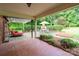 Covered patio featuring an outdoor lounge, dining area, and landscaped backyard with a brick fireplace at 4145 Wrangler Sw Dr, Concord, NC 28027