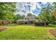 Spacious, fenced-in backyard with well-maintained lawn, mature trees, and a brick home at 4145 Wrangler Sw Dr, Concord, NC 28027