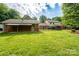 Spacious backyard featuring green grass, a brick house, and a fenced-in yard at 4145 Wrangler Sw Dr, Concord, NC 28027