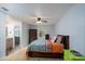 Comfortable bedroom showcasing stylish bedding, bathroom access, and modern ceiling fan at 4145 Wrangler Sw Dr, Concord, NC 28027