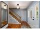 Home foyer featuring hardwood floors, staircase, decorative lighting and stained glass door at 4145 Wrangler Sw Dr, Concord, NC 28027
