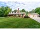 A well-maintained two-story home with attached garage, lush lawn, and mature trees at 4145 Wrangler Sw Dr, Concord, NC 28027