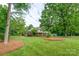 Beautifully landscaped front yard with mature trees and a well-maintained lawn at 4145 Wrangler Sw Dr, Concord, NC 28027