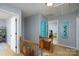 Bright hallway featuring wood banister, doorway views, and decorative accents at 4145 Wrangler Sw Dr, Concord, NC 28027