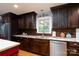 Kitchen featuring stainless steel appliances, granite countertops, dark wood cabinets, and natural lighting at 4145 Wrangler Sw Dr, Concord, NC 28027