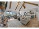 Spacious living room boasting high ceilings with beams, a stone fireplace, and seamless access to outdoor seating at 4316 Nesbit Rd, Monroe, NC 28112