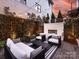 Cozy backyard patio with an outdoor fireplace, stylish seating, and string lights, perfect for evening gatherings at 443 Beaumont Ave, Charlotte, NC 28204