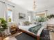 Bright bedroom with natural light, hardwood floors, neutral decor, and stylish wooden frame bed at 443 Beaumont Ave, Charlotte, NC 28204