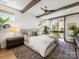 Bright bedroom featuring exposed ceiling beams, fan, neutral decor, and access to a private balcony at 443 Beaumont Ave, Charlotte, NC 28204