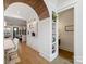 Open hallway featuring a wood archway, built in bookshelves, hardwood floors and neutral wall decor at 443 Beaumont Ave, Charlotte, NC 28204
